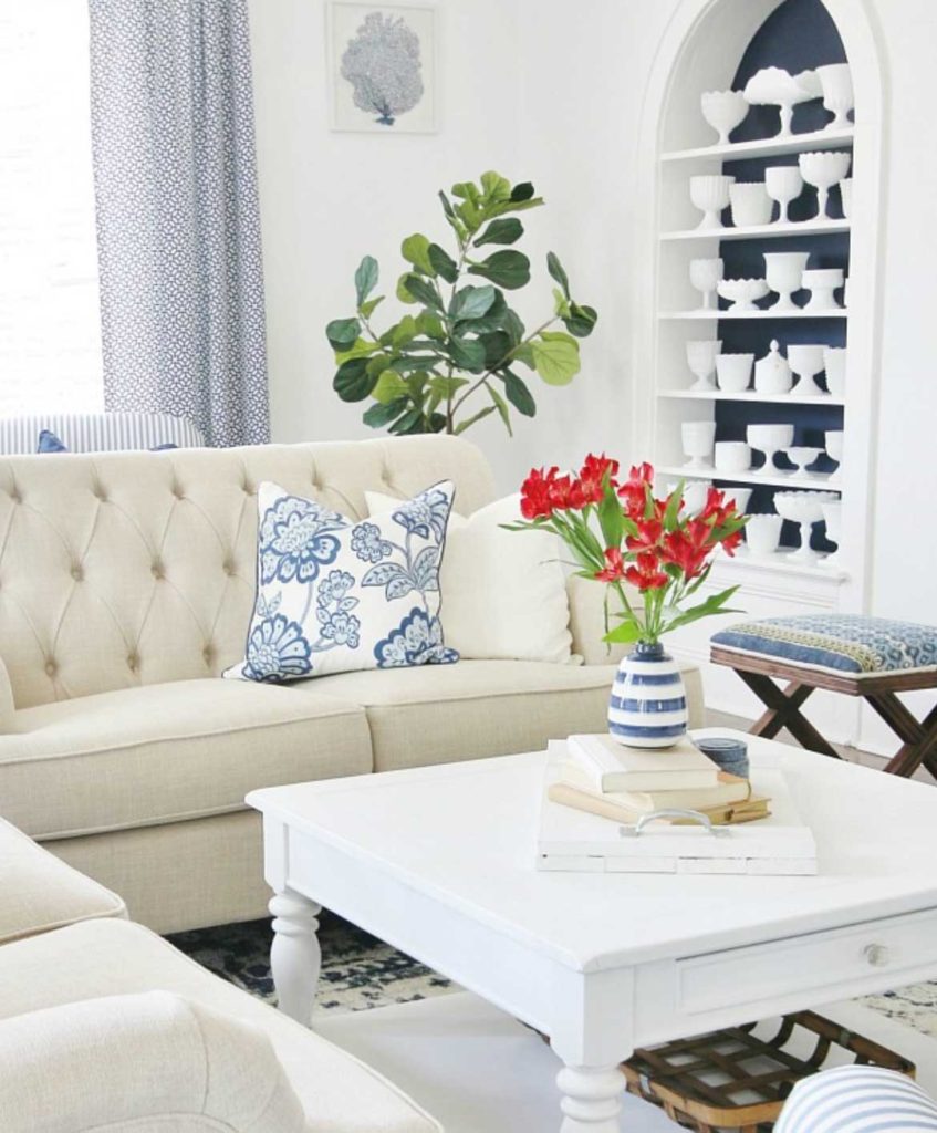 living room with white couch and white coffee table and fiddle leaf fig in the background