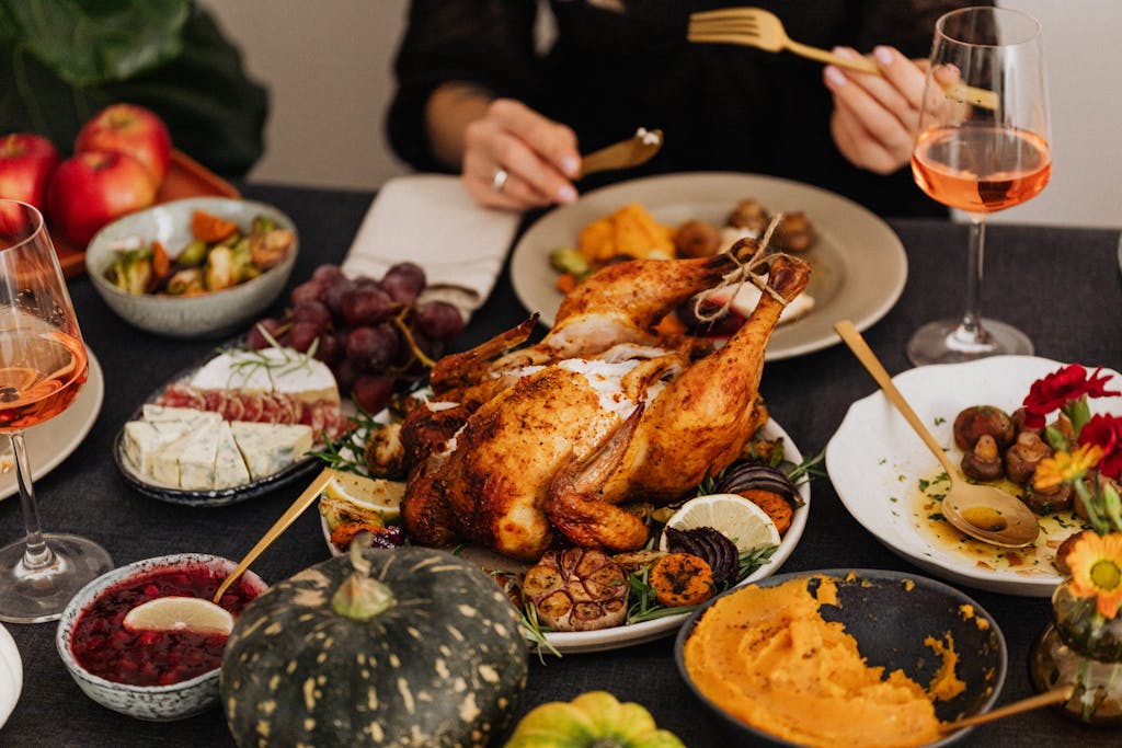 A festive Thanksgiving dinner spread featuring a golden roasted turkey, vegetables, and wine.