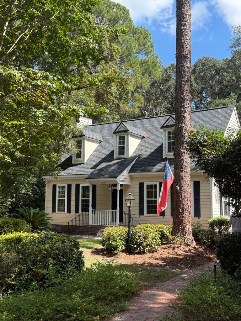 ivory colored cottage surrounded by trees