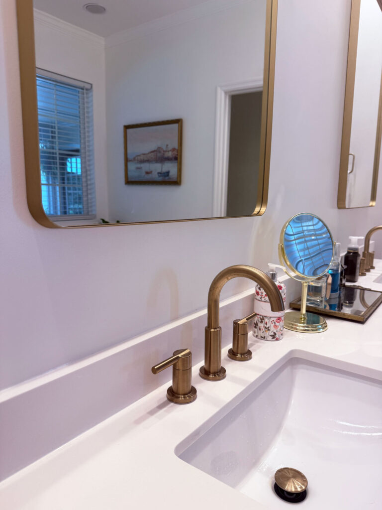 closeup of white bathroom vanity countertopw ith gold fixtures