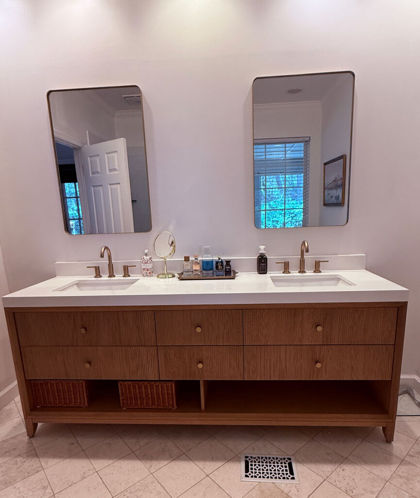 wood vanity with white top and gold mirrors