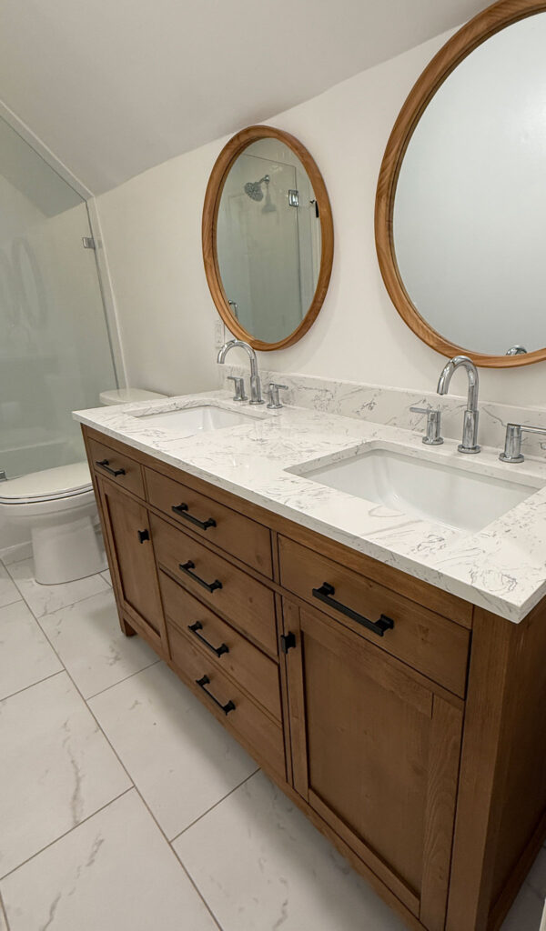 wood bathroom double vanity with white counter and round mirrors