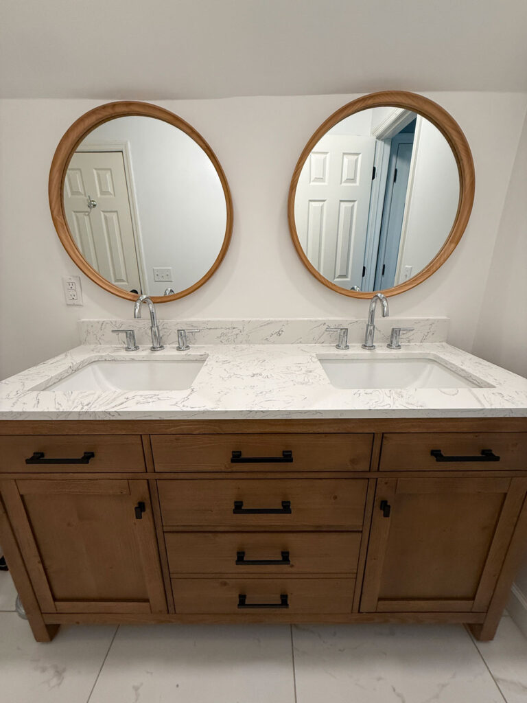 wood bathroom double vanity with white counter and round mirrors