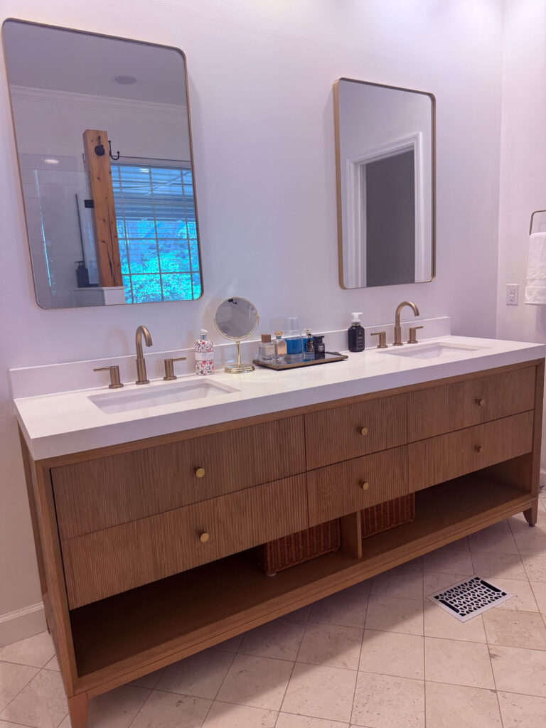 wood bathroom vanity with white countertop and gold fixtures