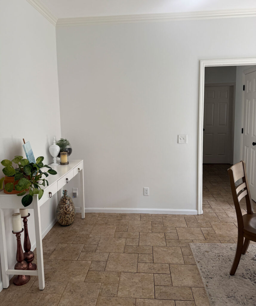 eat-in kitchen area with beige tile and white walls and white console table