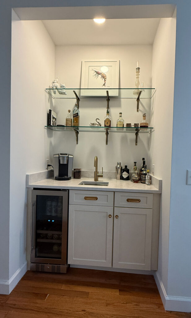 wet bar with brushed quartz counters and glass shelves